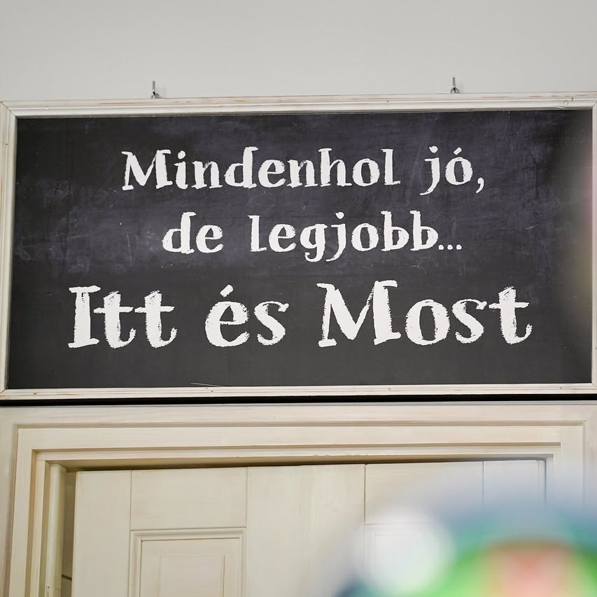 „Mindenhol jó, de legjobb... Itt és Most” felirat az étterem tábláján